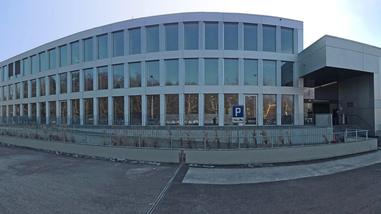 Budynek urzędu ruchu drogowego kantonu Argowia z parkingiem przed wejściem (kadr panoramy)