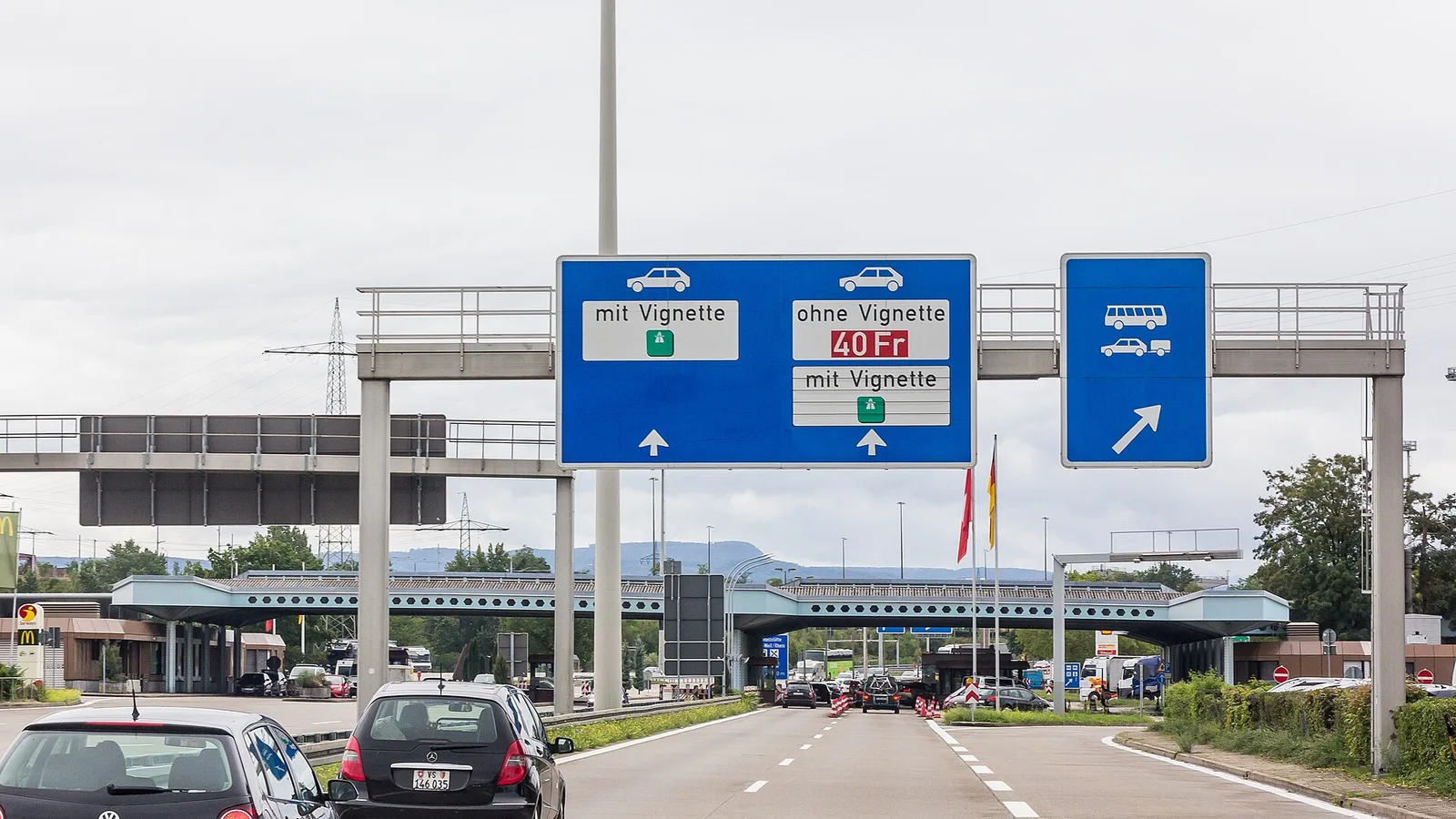 Tablica nad autostradą A5 przed przejściem granicznym Weil am Rhein–Basel: pasy dla aut z winietą i bez winiety za 40 franków
